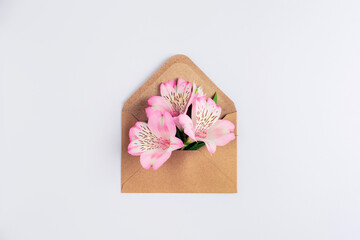 Alstroemeria flowers in envelope on white background. Top view, flat lay
