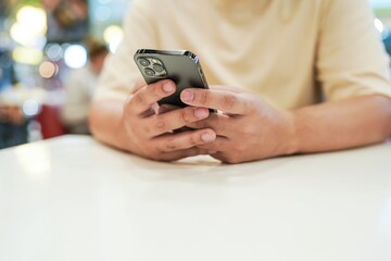 Relaxed young asian man using smart phone  spending time checking news social media.