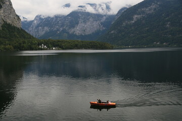 A man peacefully rowing a small boat on a lake, Austria