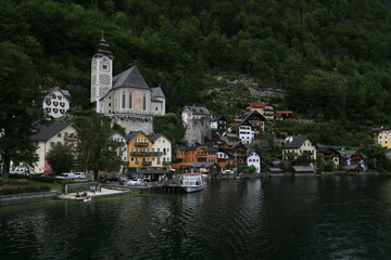 Photo of a serene lakeside town with colorful buildings and boats on the water, Austria