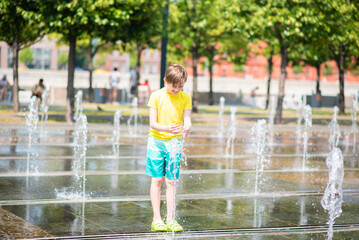 happy boy playing in dry fountain in summer