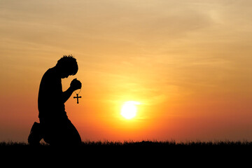 Silhouette of lonely and desperate man praying to god - obrazy, fototapety, plakaty