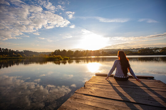Fototapeta Young woman sitting on the pier
