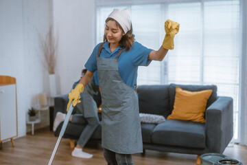 Enthusiastic house cleaning lady do various tasks with responsibility. Using mop, broom, laundry machine, cleaning supplies to wipe, scrub, and dust furniture, glassware, floors, clothes, dishes.