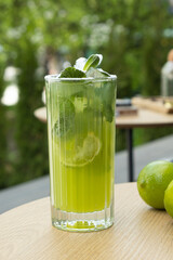 Mojito and limes on a street cafe table against greenery