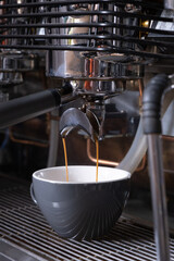 Coffee machine in working process. Coffee is poured into a cup