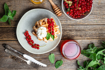 Belgian waffles with red currants in a bowl