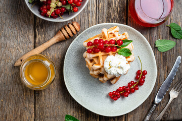 Belgian waffles with red currants in a bowl