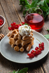 Belgian waffles with red currants in a bowl