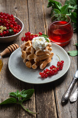 Belgian waffles with red currants in a bowl