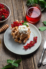 Belgian waffles with red currants in a bowl