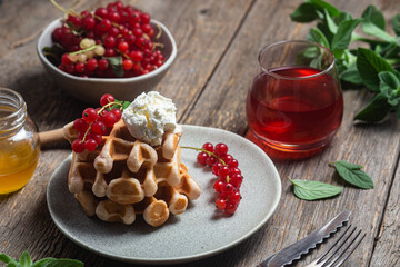 Belgian waffles with red currants in a bowl