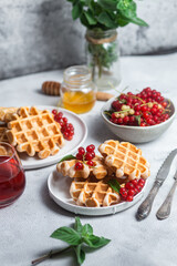 Belgian waffles with red currants in a bowl