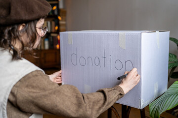 Volunteer girl eco activist signs donation box. Conscious consumption save environment, sorting out...