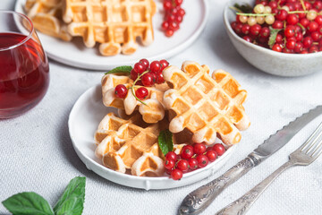 Belgian waffles with red currants in a bowl