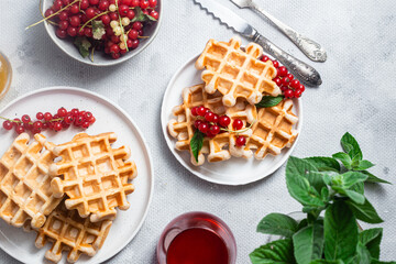 Belgian waffles with red currants in a bowl