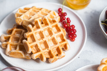 Belgian waffles with red currants in a bowl