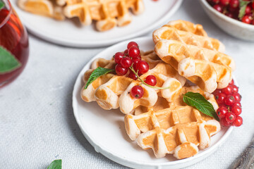 Belgian waffles with red currants in a bowl