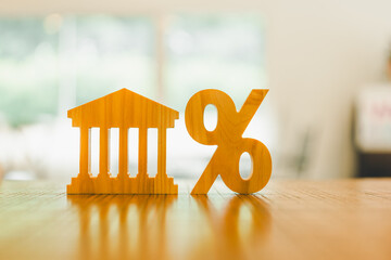 Bank symbol and Percentage model on wood table. Concepts of the banking system, rising interest...