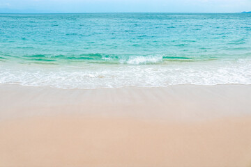 Blue ocean wave on sandy beach. Copy space.