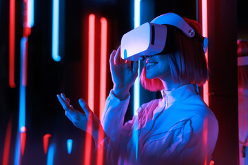 Woman in futuristic costume. Girl in glasses of virtual reality while touching air. Augmented...