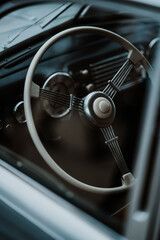 Oldtimer car dashboard. Retro car interior. Old steering wheel detail.