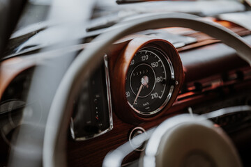 Oldtimer car dashboard. Retro car interior. Old steering wheel detail.