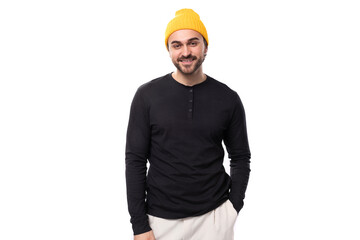 young well-groomed stylish brunette European brutal man in a black sweatshirt on a white background with copy space