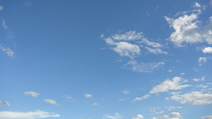 Naklejka na ściany i meble A bright sky with white clouds with blue sky background.