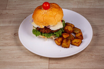 veg burger with fried sweet potato in white plate on wooden background