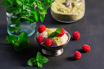 Ice cream with raspberries and mint in an iron bowl on a concrete surface. - 620636500
