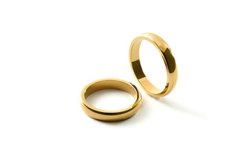 Engagement gold rings standing and lying down on isolated background