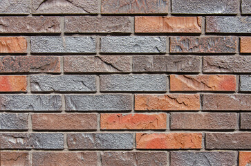 Detail of a wall with modern bricks, artificially roughened, in various colors