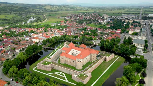 Cinematic aerial perspective of Fagaras City. Drone backwards starting from Făgăraș Citadel.  Beautiful panoramic view of all city of Fagaras. The fortress was a prison for political detainees.