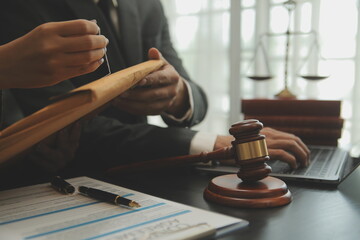 Business and lawyers discussing contract papers with brass scale on desk in office. Law, legal services, advice, justice and law concept picture with film grain effect
