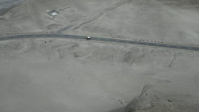 Vehicle running on Karakoram Highway near Chilas on road to Hunza Valley. This part of highway is surrounded by sand dunes and Rocky Mountains.