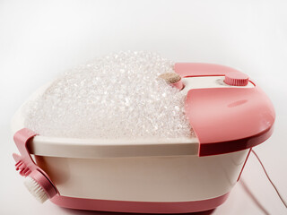 Vibrating foot massager on a white background. Foot bath close-up.