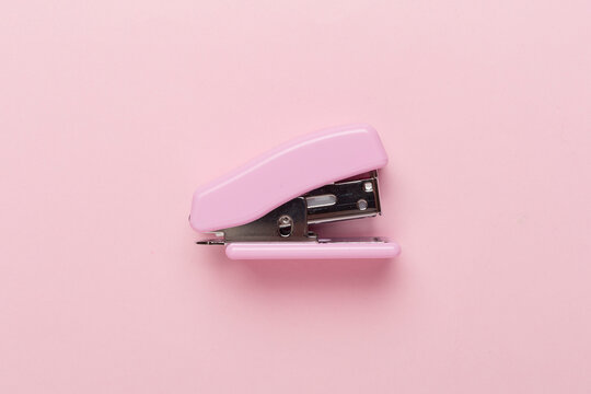 Pink stapler on color backgroung, top view