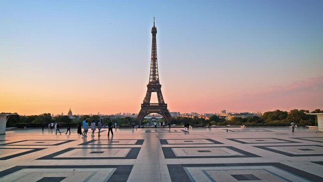 Views of the Tower from Trocadero in Paris, France. Tourists enjoy historical landmark and symbol of Paris at sunrise in Paris.