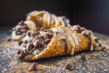 Stuffed cannoli pastry with whithe and dark chocolate. Isolated. - obrazy, fototapety, plakaty