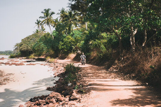 Man driving motorcycle near the beach in India