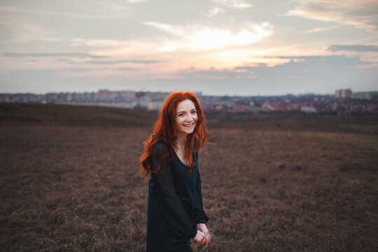 Redheaded woman on the field in autumn 