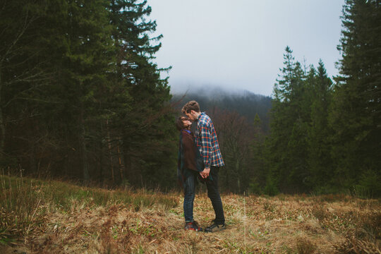 Man and woman kissing on the background of the forest in mist 