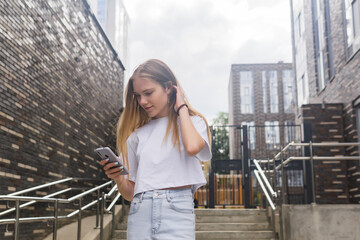 young woman with a phone on the background of city buildings