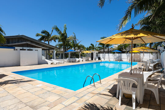 Swimming pool and lounge area with hammocks, tables and beach umbrella