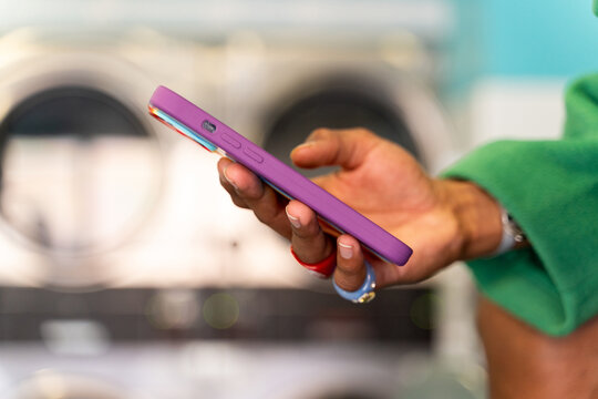 Hand holding smartphone at laundry
