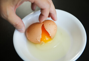 Whole eggs represent vitality and potential, cracked eggs symbolize vulnerability, while yolk represents nourishment. Contextualized against health concerns and rising inflation