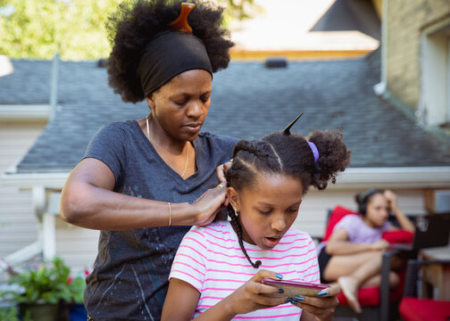 Mother combing her child's kinky curly coily hair