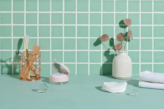 Table with bottles of cosmetic products and massage brush near w