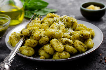 Gnocchi with Pesto, Potato Gnocchi Tossed with Basil Pesto Sauce, Italian Cuisine, Tasty Meal over Dark Background
